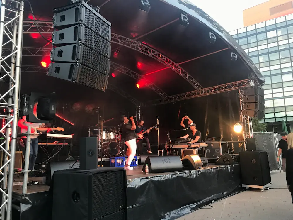 Sängerin mit Band auf einer Bühne, am Musik machen