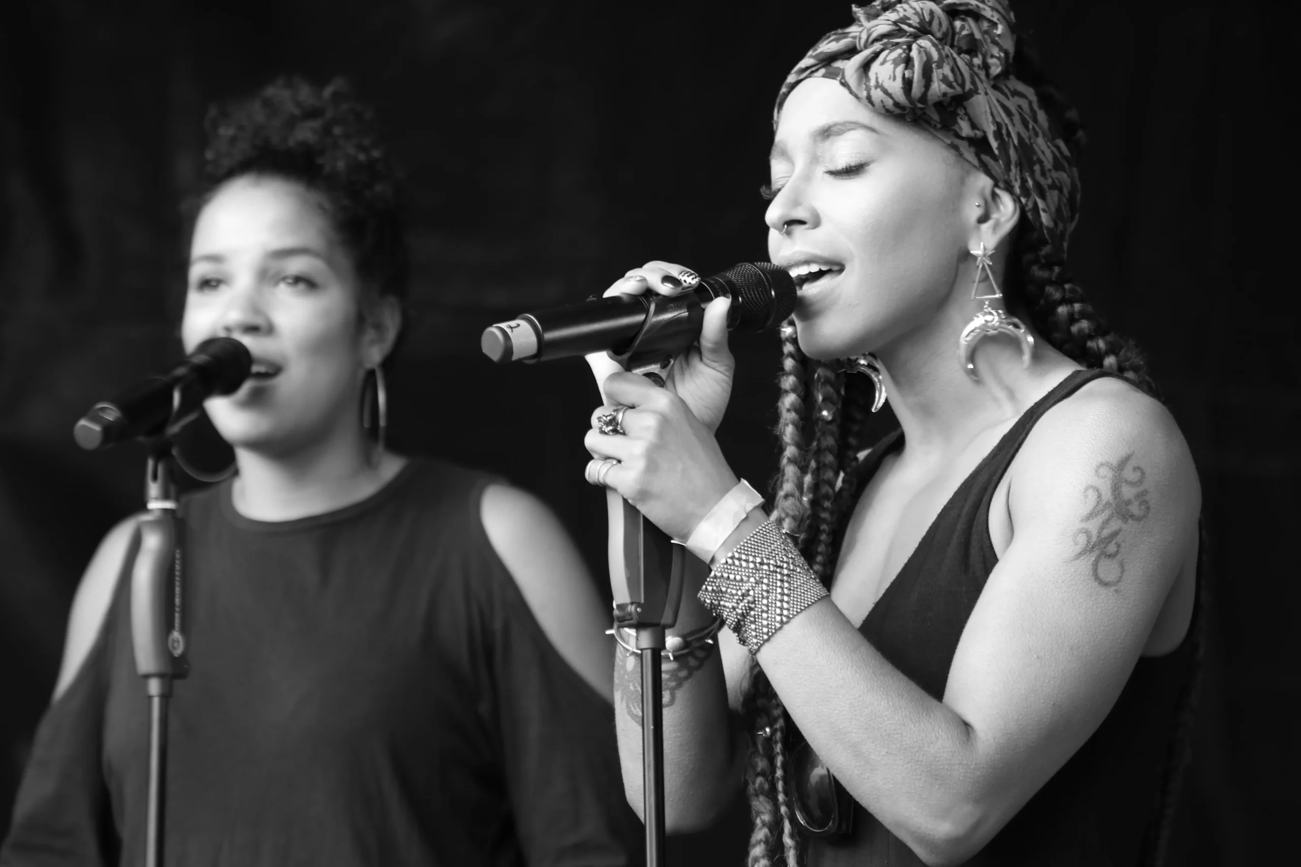 Zwei Sängerinnen stehen auf einer Bühne und singen einen emotionalen Song